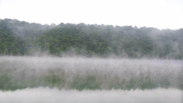 Fog over the forest with the river. Beautiful morning landscape.