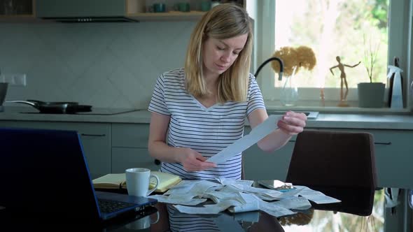 Woman Calculating Payment Bill in Kitchen