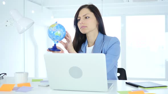 Businesswoman Holding and Reading World Globe