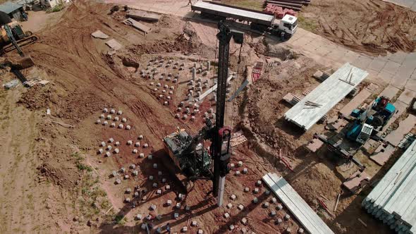 A Large Vertical Piledriving Crane Hammers Reinforced Concrete Piles Into the Ground at a