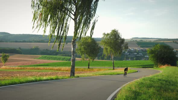 Female road cyclist speeding downhill on bicycle