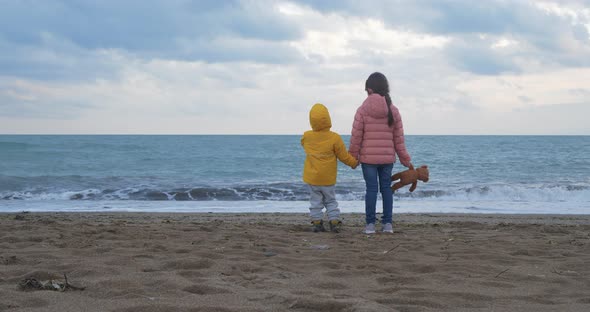 Little Children Playing on the Beach. Sister and Her Little Brother Holding Hands