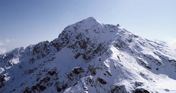 Aerial Flying Moving Backward Over Snowy Mountain Peak Ridge Establisher