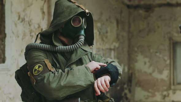 A Man in an Abandoned Building Looking at the Readings on His Arm