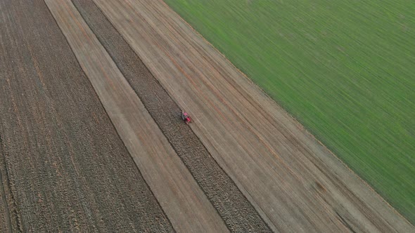 Farmer in Tractor at Work Preparing Plowing Land with Agricultural Field