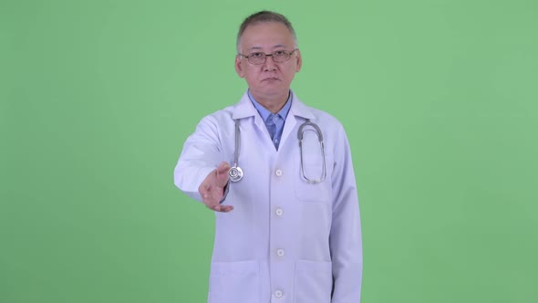 Mature Japanese Man Doctor Giving Handshake