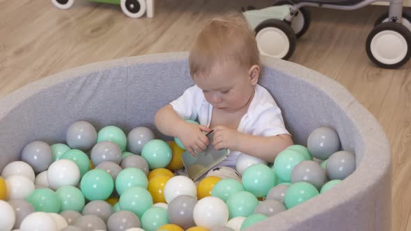 Kid Playing with Smartphone in Ball Pit at Home