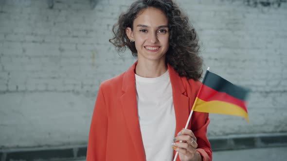 Slow Motion Portrait of Attractive Mixed Race Woman Holding German Official Flag Standing Outdoors