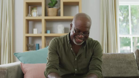Portrait of smiling senior african american man making video call in living room