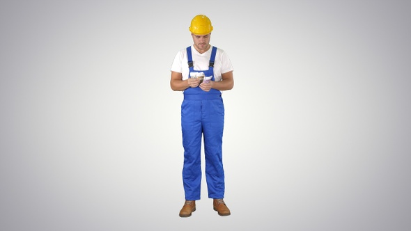 Builder counting money standing on gradient background.