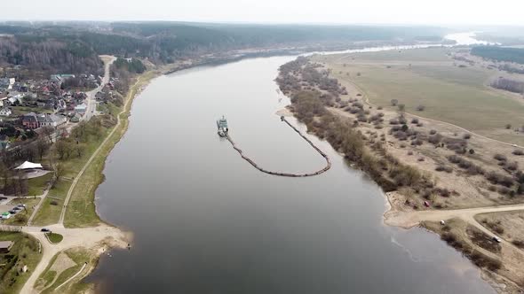 Industrial boat deepening Nemunas river in high angle drone view