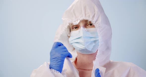 Tired Doctor or Nurse Removes Protective Suit and Goggles with Mask After Work Shift of Corona