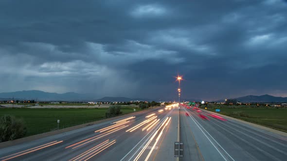 Time lapse of traffic driving on highway as storm and lightning passes
