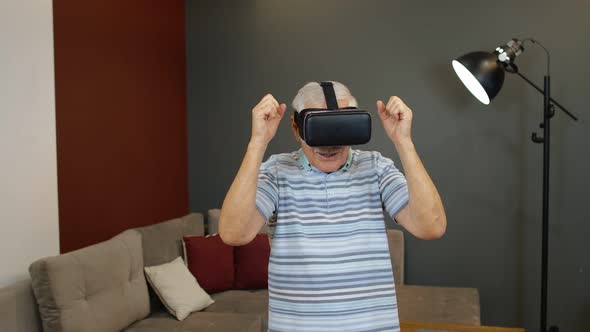 Happy Senior Man Using Virtual Reality Headset Glasses, Trying To Touch Something, Watching 3D Video