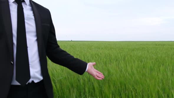 Farmer  Agronomist Demonstrates His Wheat Field with His Hand