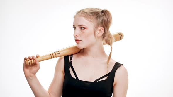 Young Beautiful Girl Looking at Camera Brutally Holding Bat Over White Background