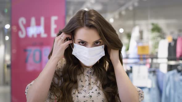Video portrait of young woman putting on a protective mask. Shot with RED helium camera in 8K.