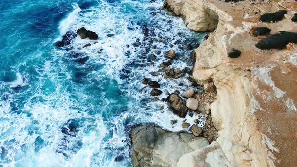 Pure Blue Ocean Water Waves with Light Reflections Crush Mountain at Beautiful Coastline Slow Motion