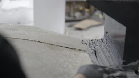 Worker applying cement on pizza oven in workshop