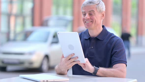 Outdoor Cheerful Middle Aged Businessman Doing Video Chat on Tablet