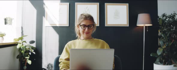 Young Woman Chatting on Video Call on Laptop at Home