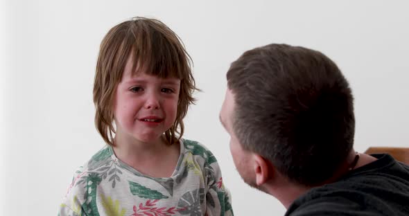 Little Preschooler Boy in Tshirt Cries and Father Calms