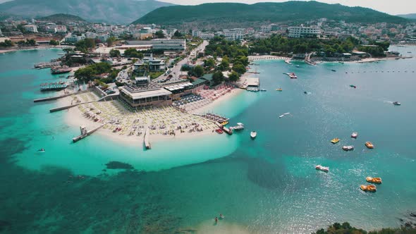 Aerial Azure Beach with Empty Sun Loungers and Boats Balkan Sea Coast Albania
