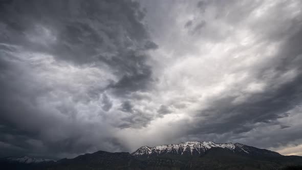 Moody clouds moving towards mountain top in time lapse