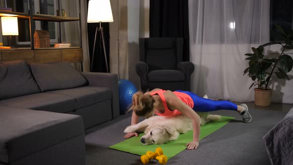 Active Woman Doing Pushups From the Floor with Pet