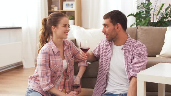 Happy Couple Drinking Red Wine at Home