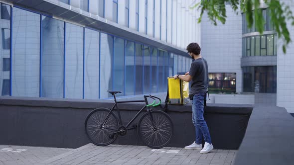 Courier Zipping His Delivery Backpack and Ready to Go