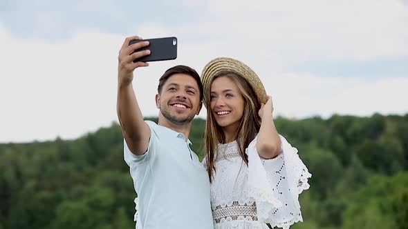 Couple Making Photo On Mobile Phone In Nature