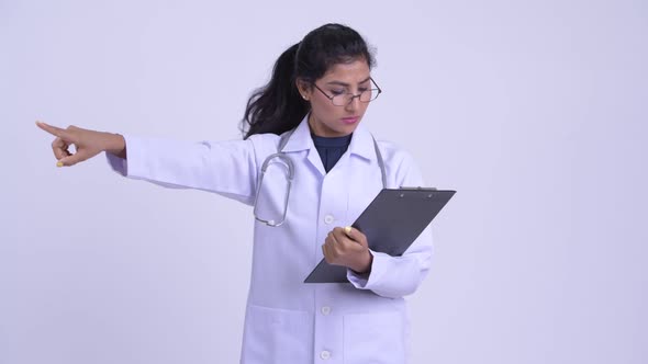 Young Beautiful Persian Woman Doctor Directing While Reading on Clipboard