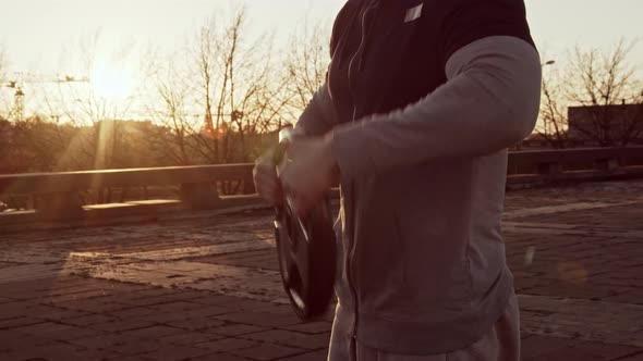 Young and fit man having evening workout outdoor. Urban sunset background.