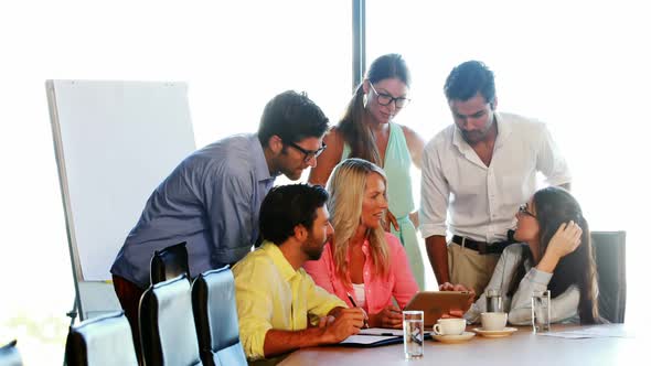 Businesspeople having a discussion while using digital tablet