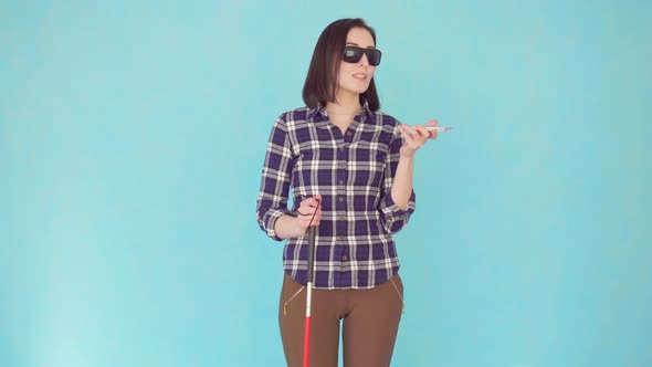 Smiling Blind or Visually Impaired Young Woman with Glasses and a Cane