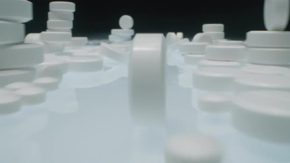 White Tablet Rolling through Stacks of Medicines