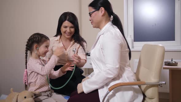 Joyful Child Listening To Doctor with Stethoscope