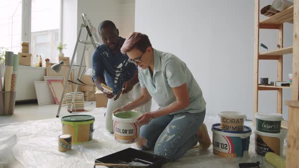 Multiethnic Couple Preparing Paint for Home Renovation