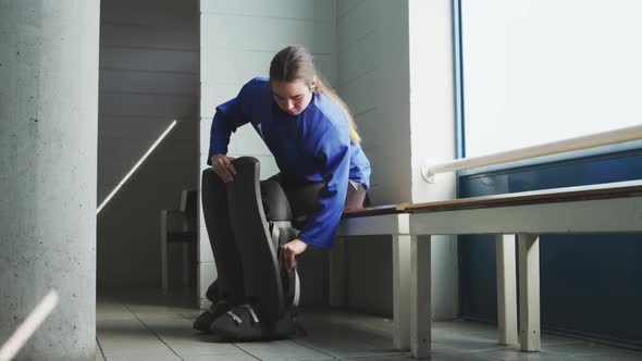 Female player tying her equipment in dressing room