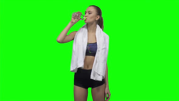 Sportswoman Is Drinking Water and Towels. Green Screen