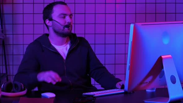 Young Man Programmer or Hacker Working on Computer at Night