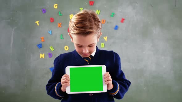 Schoolboy showing digital tablet in classroom