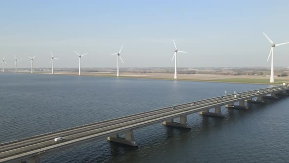 Flyover along Ketelbrug bridge over lake, windmills in lake shore. the Netherlands.