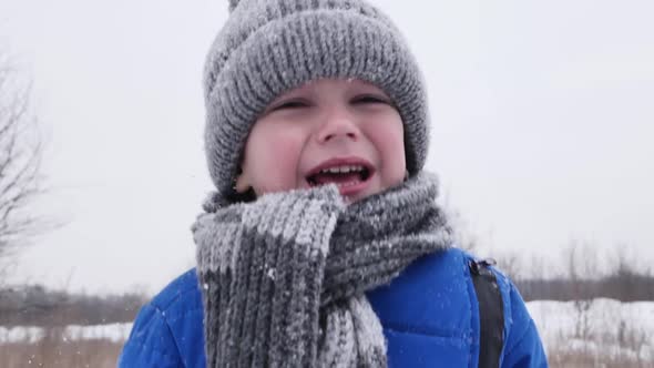 Little Boy in the Cold Cries in the Snowcovered Forest in Winter