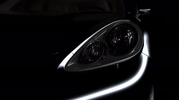 the black car gradually emerges from the darkness due to the illumination