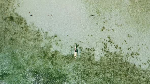 Aerial Drone Bird Eye Perspective View of Local Banca Boat in Shallow Lagoon Water