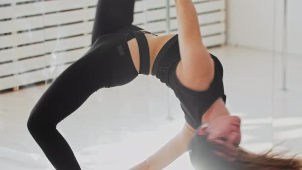 Young Gymnastic Woman Spinning on the Acrobatic Ring Hanging Under the Ceiling