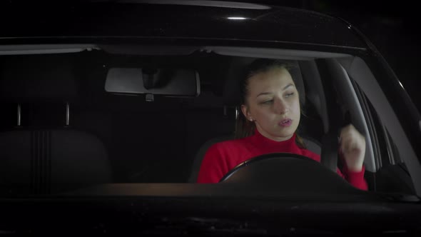 The Woman Behind the Wheel Is Fastened with a Seat Belt and Turns on the Wipers