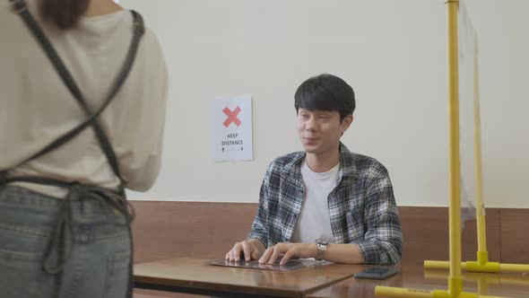 Man order food with tablet in restaurant eating food and keep distance